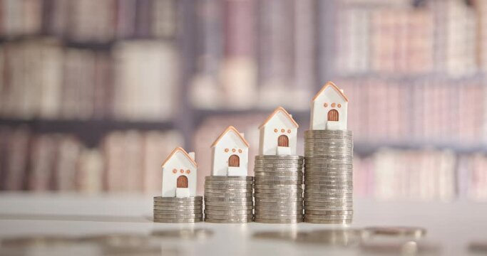 Mortgage loan or home equity loan, financial concept : Tiny model residential house perched atop coin stacks, depicting home loan or borrowing money to purchase a new home for first time homebuyer.	