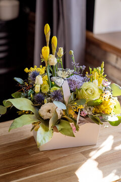 a beautiful delicate spring bouquet of daffodils and eustom. floral arrangement in yellow green and purple