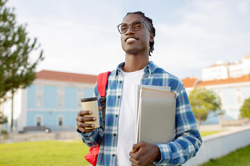 Cheerful Black Guy Student Posing With Laptop And Workbooks Outside
