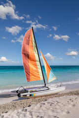 Colorful sailing catamaran on the beach of the Varadero -  Cuba.
Turquoise blue Atlantic water and blue sky with white clouds.