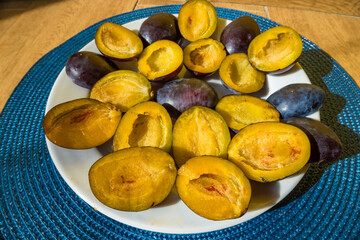 sweet, fragrant dark blue plum, amber I also halved plums on a white plate