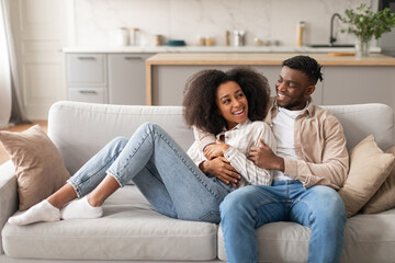 Happy Loving Millennial Black Couple Chilling In Modern Living Room