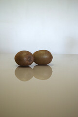 The reflection of some kiwis on a table