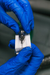 Vertical photo preparing tattoo needle with precision and care. Concept business, art.