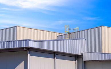 Group of storage rooms with warehouse and industrial buildings in factory area against blue sky background