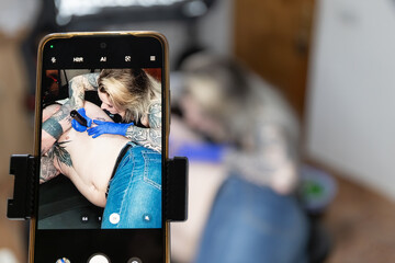 Horizontal photo smartphone View of Tattoo Session in Progress. Concept business, art.