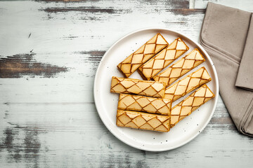 Sfogliatine, an Italian puff pastry with glaze on a plate on white background, top view