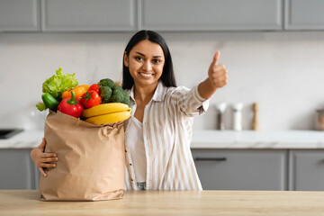 Happy young hindu woman with paper bag full of grocery - obrazy, fototapety, plakaty