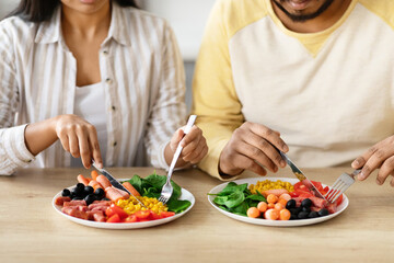Cropped of couple sitting at table, eating breakfast