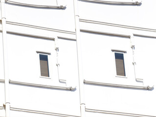 Windows of an apartment building on a white wall background.