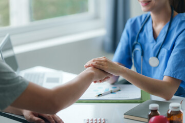 Caring nurse holding a patient's hand, providing comfort and support during a medical consultation.
