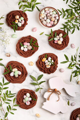 Easter chocolate shortbread cookies in a shape of nest filled with colorful egg candies. Delicious homemade festive food. Top view