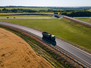 Red tipper truck on street road highway transportation. Semi-truck countryside aerial view. - 727957003