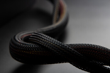 Cable snake skin. Black braided wires in bundle on black background. Braided Sleeving. Data line protection. Wire Flame-retardant nylon tube - 727957006