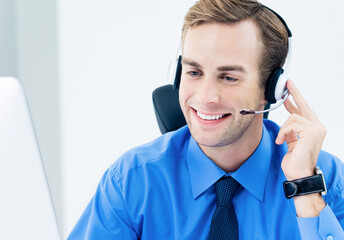 Portrait image - happy smiling support phone male operator wearing headset, blue shirt and tie,...