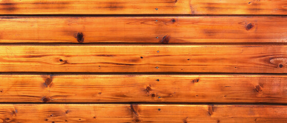 Background and texture of yellow longitudinal varnished boards. Panorama. View from above.