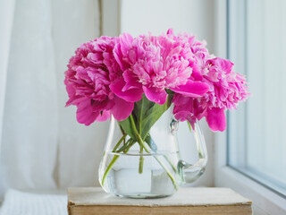 Bouquet of bright flowers standing in a vase on the table. Close-up, no people. Concept of preparation for a holiday. Congratulations for relatives, friends and colleagues