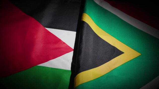South Africa and Palestine flags on turntable on dark background