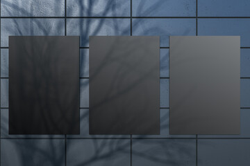 Creative outdoor dark tile wall with tree shadow and black mock up posters. Urban design concept. 3D Rendering.