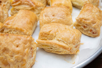 freshly baked puff pastry squares with cheese in tray