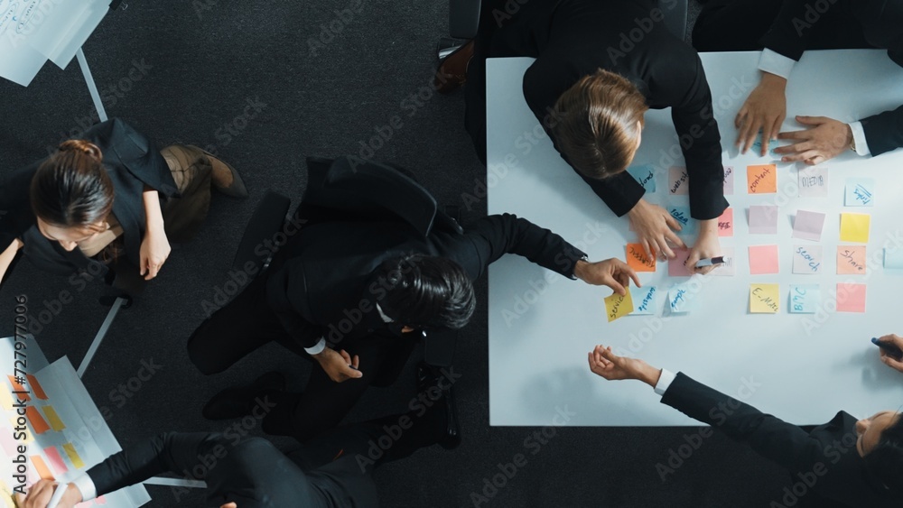 Poster top down aerial view of business group sharing and brainstorming idea by using sticky notes at meeti
