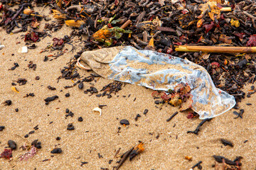 garbage on the beach, condom on the seashore close-up top view. ecological problems