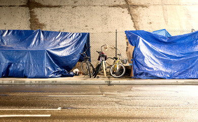 A homeless camp with bikes under a bridge during a rain storm 001