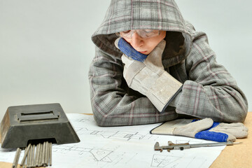 A young welder examines an assembly drawing before work.