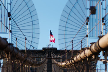 Drapeau américain sur un pilier du Brooklyn bridge reliant Brooklyn à Manhattan - obrazy, fototapety, plakaty