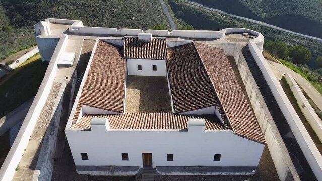 Aerial drone view of San Marcos Castle in a mountain of Sanlucar de Guadiana village in Huelva province, Andalusia, on the banks of Guadiana river, in the border of spain with portugal