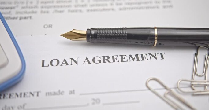 Business loan agreement or legal document concept : Fountain pen on a loan agreement paper form. Loan agreement is a contract between a borrower and a lender, a compilation of various mutual promises.