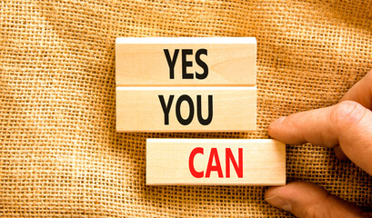 Motivational and Yes you can symbol. Concept words Yes you can on beautiful wooden blocks. Beautiful canvas background. Businessman hand. Business motivational and Yes you can concept. Copy space.