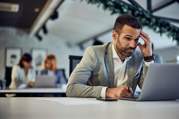 A businessman working at the co-working space, working on a new online project.