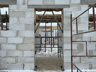 House building in progress - close front view of fresh built walls with concrete elements and...