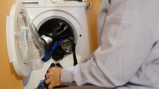 A person loading dirty clothes. Promoting gender equality, shared responsibility, and teamwork in household chores, reflecting the commitment of both men and women to family well-being.