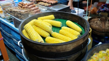Steamed corn and other snacks sold at street food market.