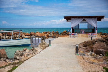 Fishing boat docked by a gazebo along the ocean 