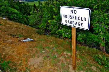 Local citizens have to be reminded not to throw garbage on a slope that overlooks their town (Upper Left), Northern California 