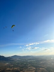 PHOTOGRAPH OF PARAGLIDERS FLYING FROM THE CHALCHIHUAPAN HILL, PUEBLA, MEXICO