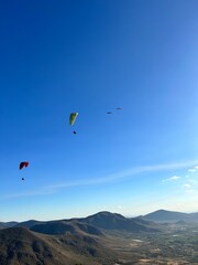 Fototapeta na wymiar PHOTOGRAPH OF PARAGLIDERS FLYING FROM THE CHALCHIHUAPAN HILL, PUEBLA, MEXICO
