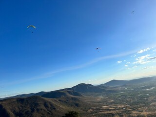 PHOTOGRAPH OF PARAGLIDERS FLYING FROM THE CHALCHIHUAPAN HILL, PUEBLA, MEXICO