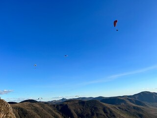 PHOTOGRAPH OF PARAGLIDERS FLYING FROM THE CHALCHIHUAPAN HILL, PUEBLA, MEXICO
