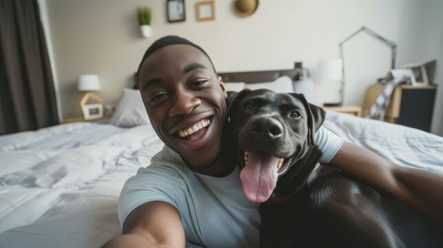 Smiling african americane young man with lovely dog taking selfie in a hotel room. Pet friendly hotel, friendship, relax, social media profile picture and memory, influencer, pet owner 
