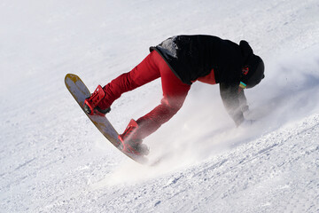 Snowboarder performs a trick on a snowy track. Copy space.