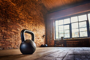 Black kettlebell in the gym with brick wall background