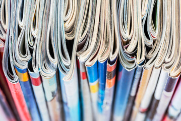 Row of magazine newspapers stacks with toned blur background