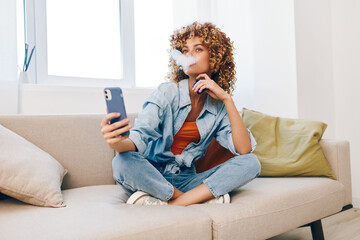 Cozy Sofa, Happy Woman: Holding Phone and Smiling while Relaxing at Home on Couch.
