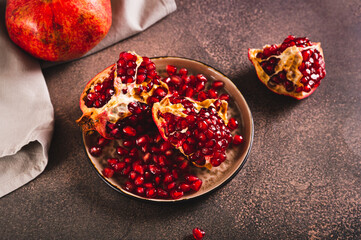 Fresh tasty pomegranate divided into pieces on a plate on the table