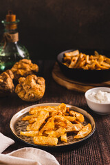Pieces of celery root fried with paprika on a plate on the table vertical view