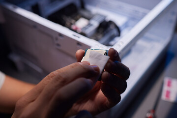 Cropped image of an engineer showing a computer microchip on the foreground